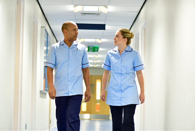 Two nurses walking and talking, representing professional development opportunities in nursing.