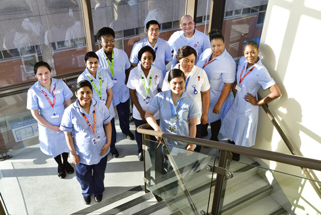 A group of smiling nurses posing together, representing career opportunities in nursing.